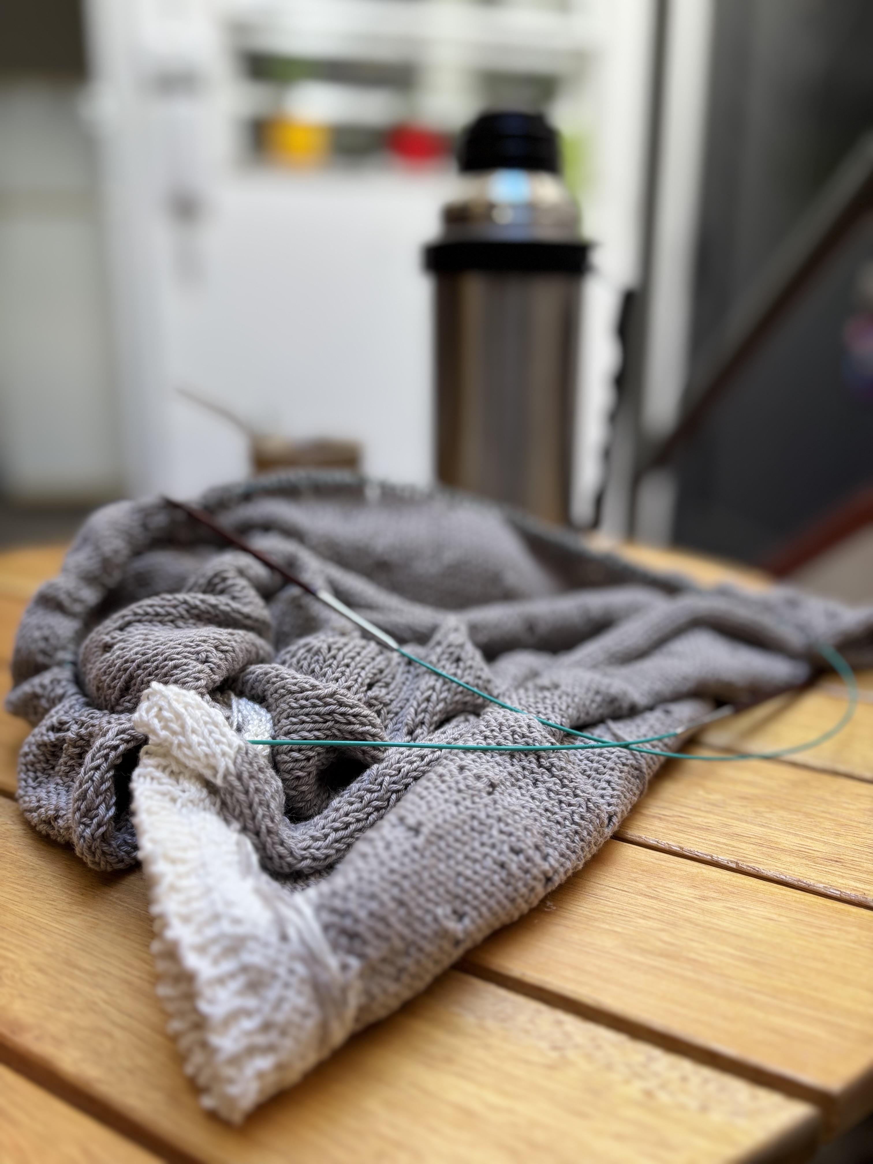 Tejido con agujas sobre mesa de madera